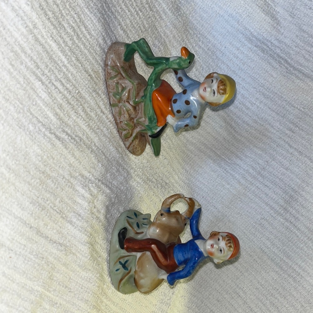 2 figurines: Boy on a Beetle and Boy on a praying mantis.